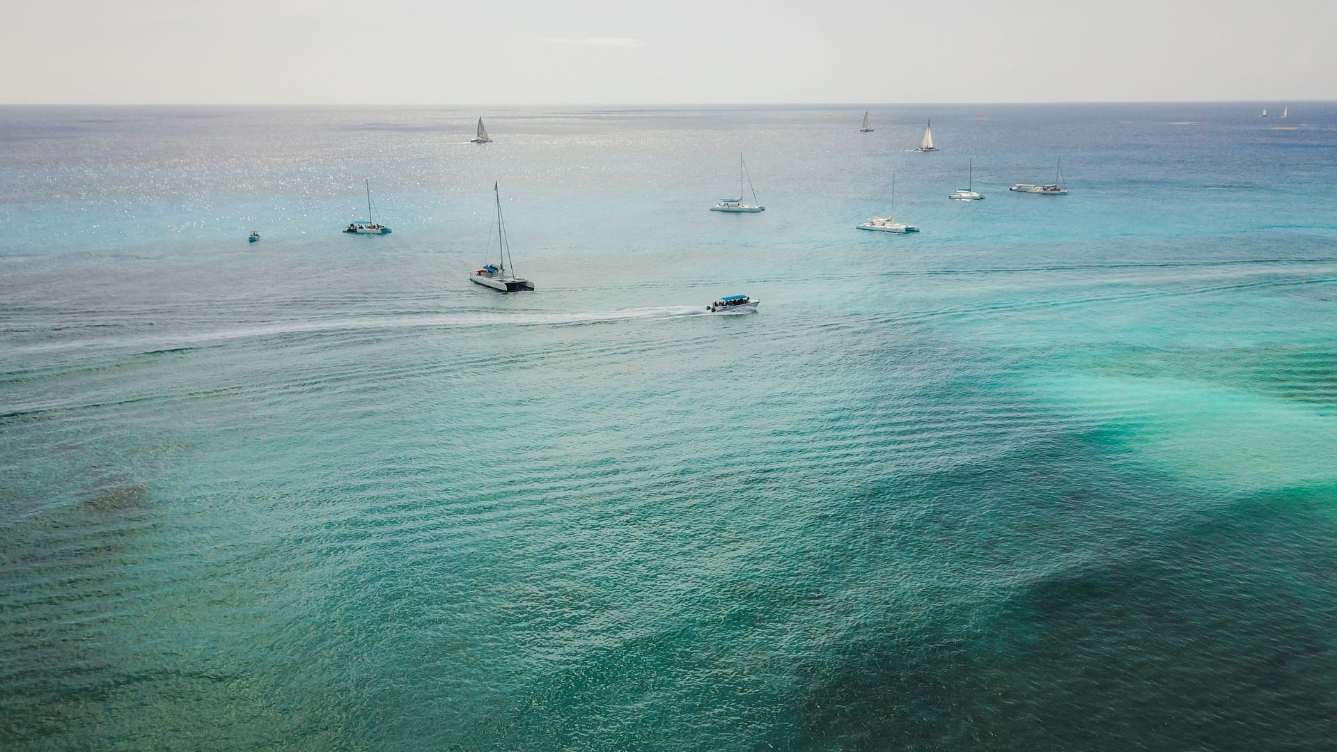 Boats on the sea. The boat is floating on the emerald clear sea between coral reefs. Aerial view